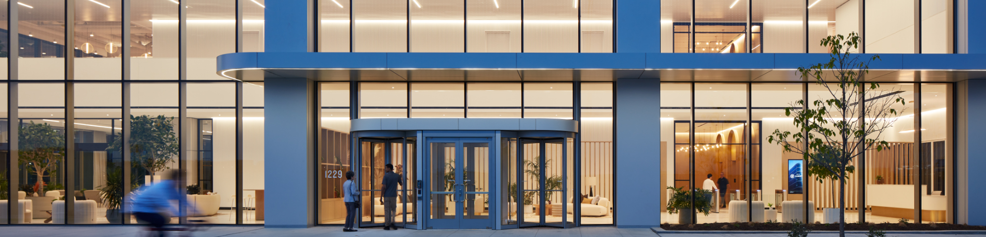 Beautiful view of a lit interior space from the exterior of the building, designed by AKLD